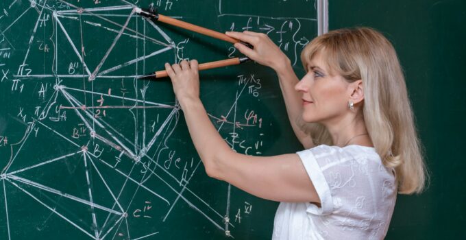 Back to school. The professor solves the problem at the blackboard