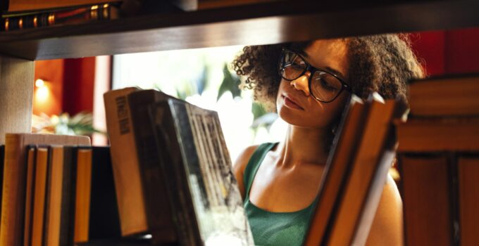 Happy African American female student studing in university library