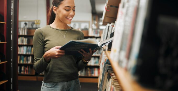 Reading, library book and woman student with a smile about learning, books and college study. Unive