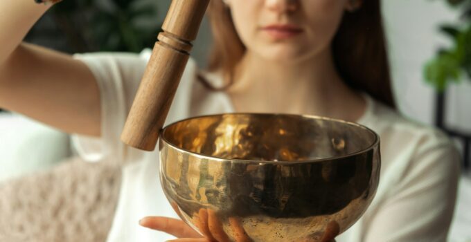 Young woman playing on a singing bowl.Tibetian healing sounds for yoga and meditation.